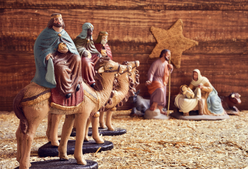 the three kings on their camels and the holy family in a rustic nativity scene